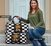 A stylish Racing Mom Travel Bag featuring a checkered flag pattern with the words "Racing Mom" and vibrant orange accents, carried by a model.