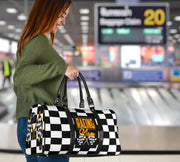 A stylish Racing Mom Travel Bag featuring a checkered flag pattern with the words "Racing Mom" and vibrant orange accents, carried by a model.