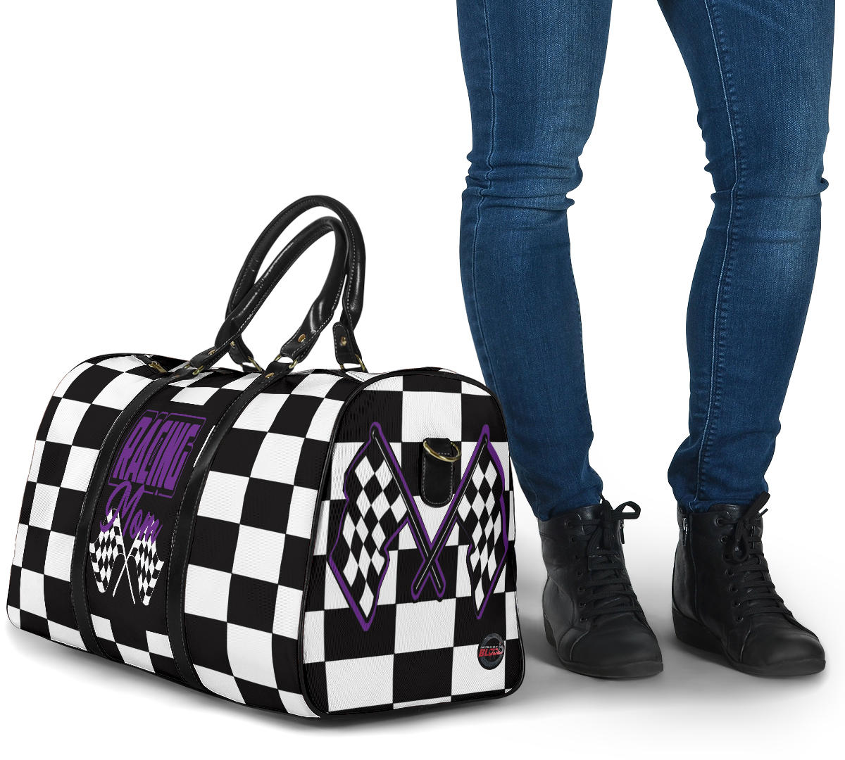 A stylish Racing Mom Travel Bag featuring a checkered flag pattern with the words "Racing Mom" and vibrant purple accents, carried by a model.