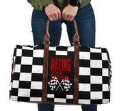 A stylish Racing Mom Travel Bag featuring a checkered flag pattern with the words "Racing Mom" and vibrant red accents, carried by a model.