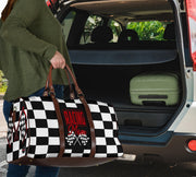 A stylish Racing Mom Travel Bag featuring a checkered flag pattern with the words "Racing Mom" and vibrant red accents, carried by a model.