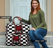 A stylish Racing Mom Travel Bag featuring a checkered flag pattern with the words "Racing Mom" and vibrant red accents, carried by a model.