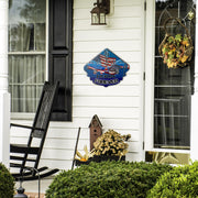 Demolition Derby Forever sign beside a front door, black rocking chair and seasonal plants.