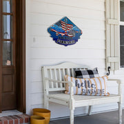 Demolition Derby USA metal sign displayed above a white porch bench with decorative pillows.