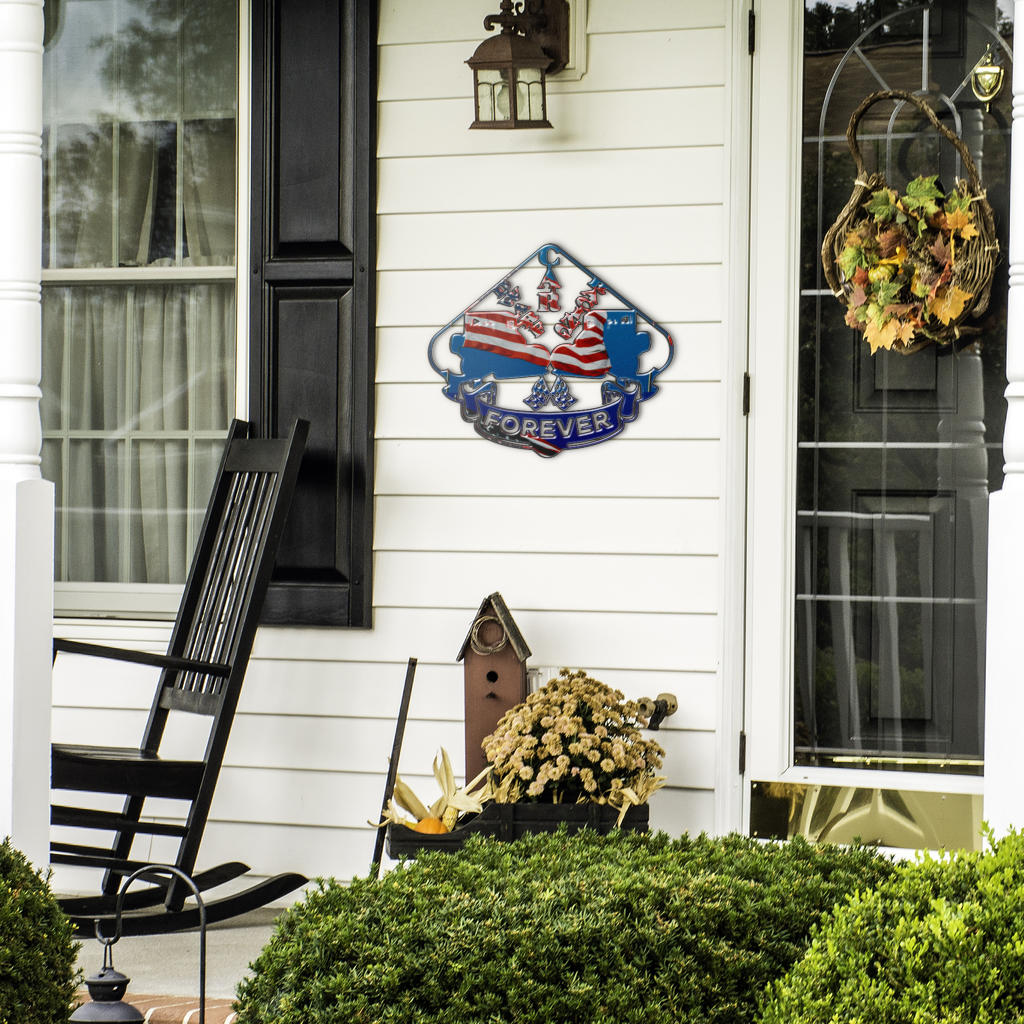 Dwarf Car Racing Forever sign beside a front door, black rocking chair and seasonal plants.