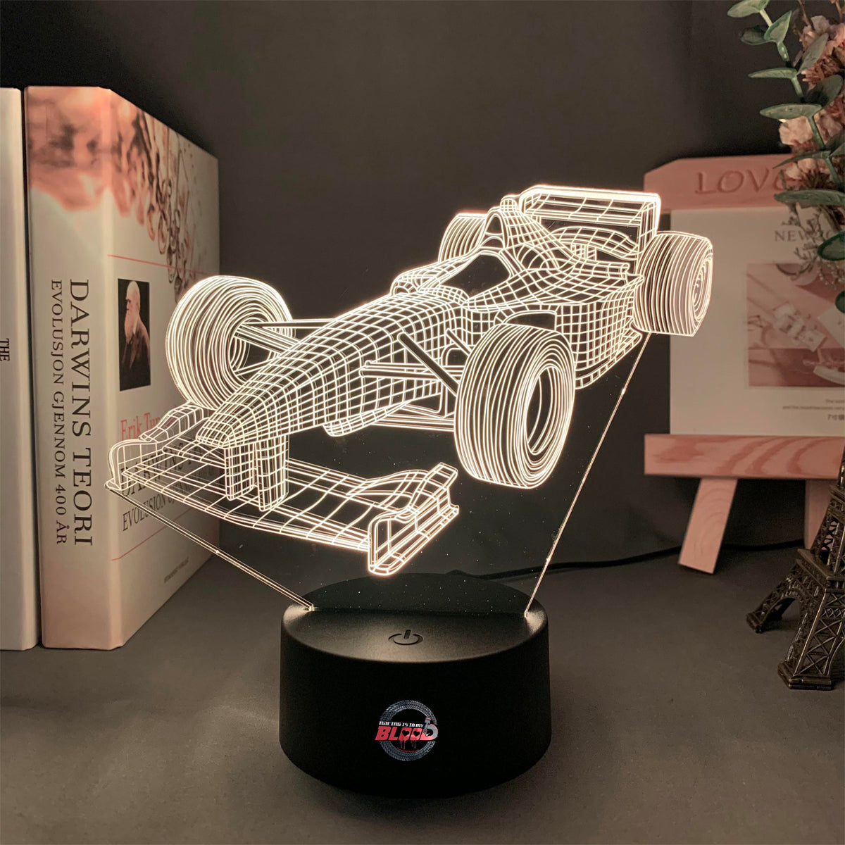 Formula One 3D LED Lamp featuring a sleek open-wheel racer silhouette glowing in a vibrant, racing purple on a modern black base.