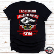 Heartfelt drag racing apparel featuring a fist-bump graphic and the text "I Asked God For A Drag Racing Partner He Sent Me My Son," available in t-shirts, tanks, and hoodies.