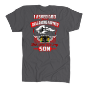 Heartfelt drag racing apparel featuring a fist-bump graphic and the text "I Asked God For A Drag Racing Partner He Sent Me My Son," available in t-shirts, tanks, and hoodies.