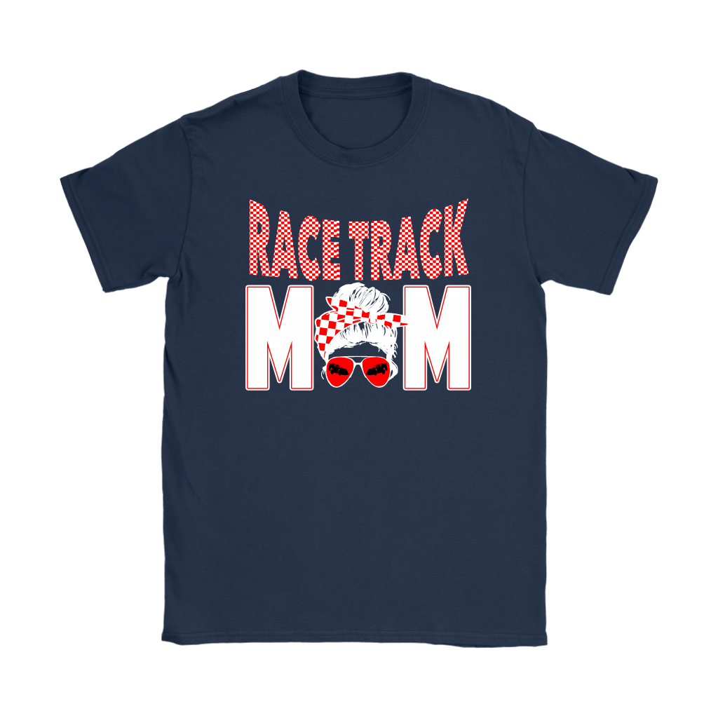 High-performance apparel mockup featuring a woman sitting on the grandstand bleachers at a dirt racing arena, wearing a premium black t-shirt with a sharp white and red "Race Track Mom" graphic showing a late model dirt car.