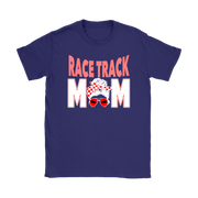 High-performance apparel mockup featuring a woman sitting on the grandstand bleachers at a dirt racing arena, wearing a premium black t-shirt with a sharp white and red "Race Track Mom" graphic showing a late model dirt car.