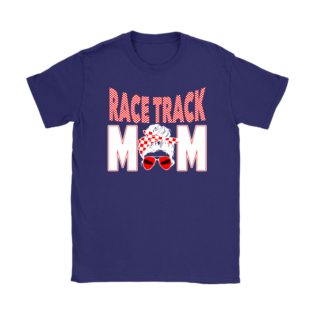High-performance apparel mockup featuring a woman sitting on the grandstand bleachers at a dirt racing arena, wearing a premium black t-shirt with a sharp white and red "Race Track Mom" graphic showing a late model dirt car.