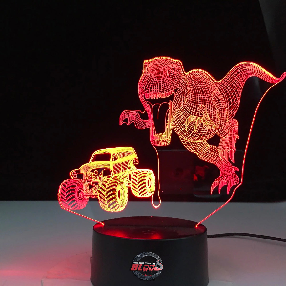 Monster Truck T-Rex 3D LED Lamp showing a roaring dinosaur-themed truck silhouette glowing in a vibrant orange on a modern black base.
