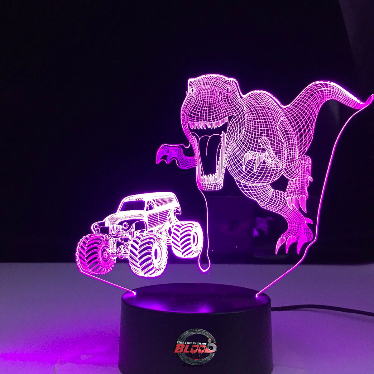 Monster Truck T-Rex 3D LED Lamp showing a roaring dinosaur-themed truck silhouette glowing in a vibrant orange on a modern black base.