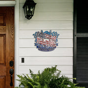 Motocross Forever metal sign on white porch siding beside a wooden door and fern.