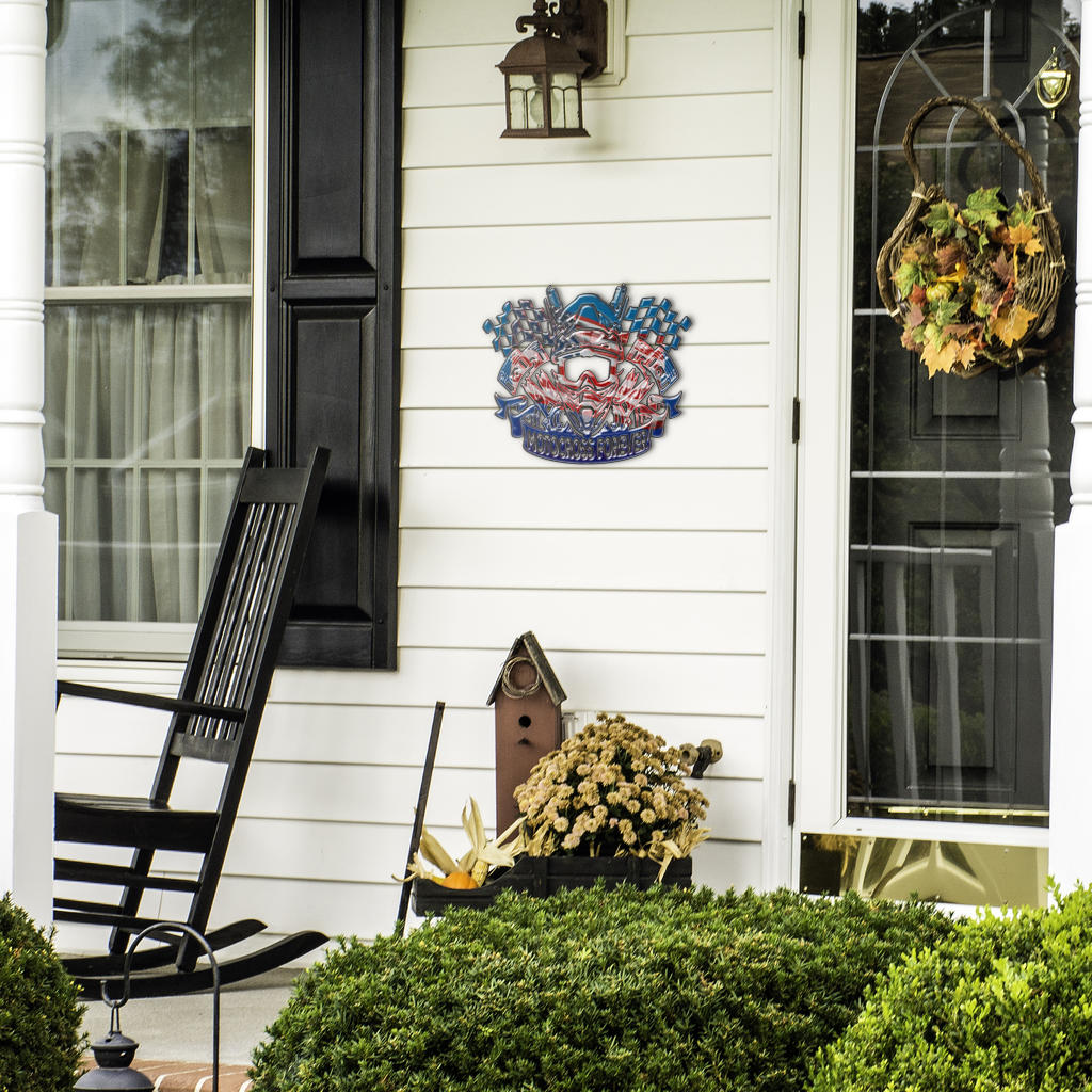 Motocross Forever sign beside a front door, black rocking chair and seasonal plants.
