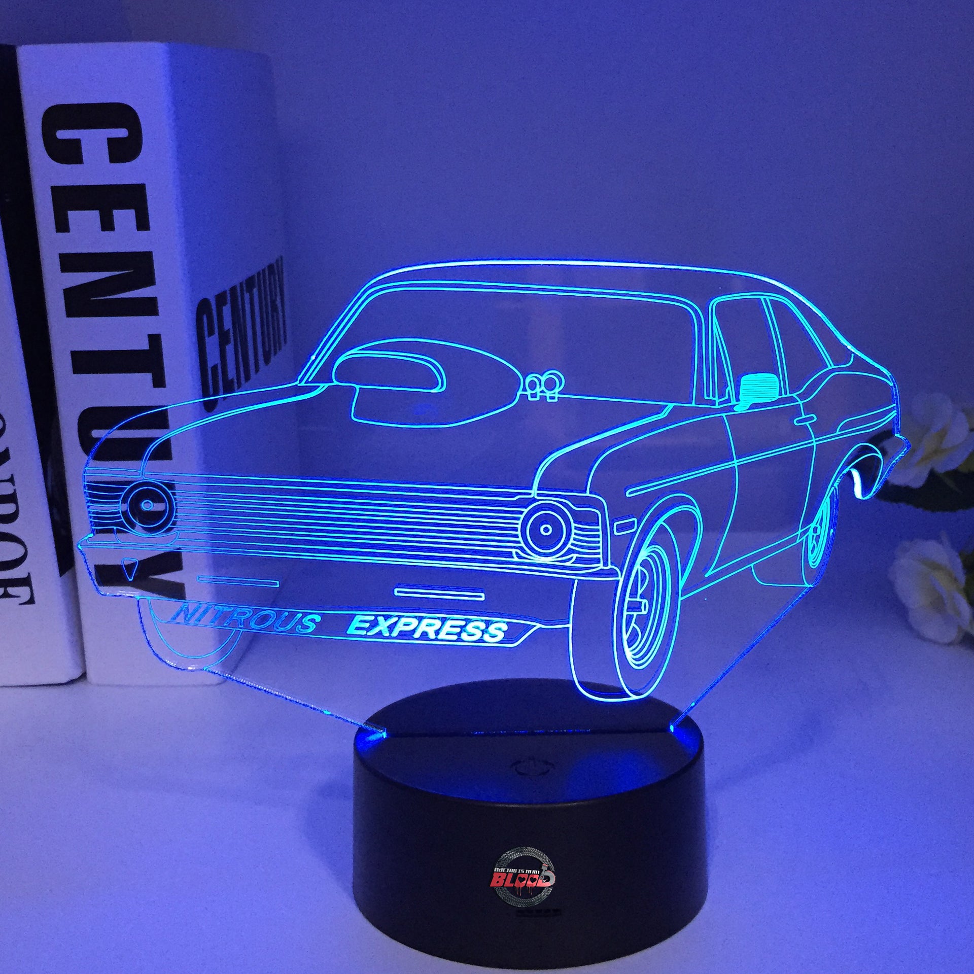 Nova Express Nitrous 3D LED Illusion Lamp showing an aggressive drag racing Chevy Nova silhouette in a vibrant blue glow on a premium black base.