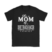Premium black apparel mockup featuring a woman sitting on the wooden grandstand bleachers at a dirt track arena, wearing a soft custom t-shirt with a bold white graphic that reads "I'm a MOM of a DIRT TRACK RACER nothing scares me".