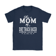 Premium black apparel mockup featuring a woman sitting on the wooden grandstand bleachers at a dirt track arena, wearing a soft custom t-shirt with a bold white graphic that reads "I'm a MOM of a DIRT TRACK RACER nothing scares me".