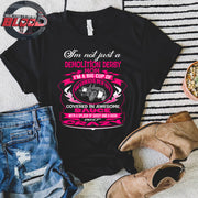 Premium women's black graphic t-shirt mockup featuring a vibrant pink and white custom design that reads "I'm not just a Demolition Derby Mom, I'm a big cup of wonderful covered in awesome sauce with a splash of sassy and a dash of crazy" with a derby car illustration.