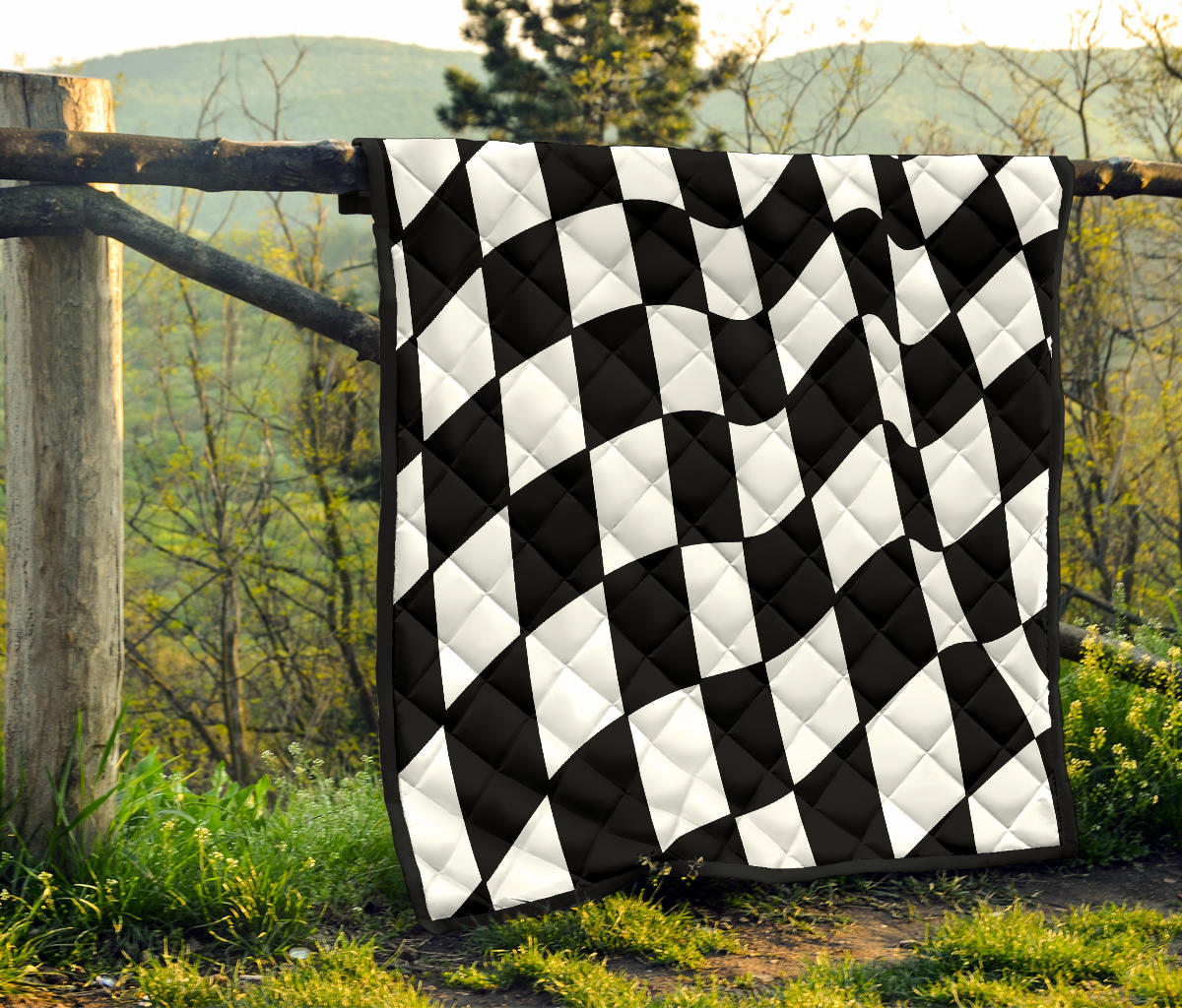 a checkered quilt is hanged on a tree branch