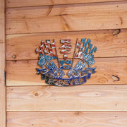 Racing USA metal sign with piston and flag artwork displayed against natural wood planks.