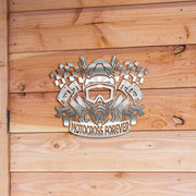 A custom metal sign with a design that includes checkered flags and the text 'MOTORCROSS FOREVER' mounted on a wooden wall.
