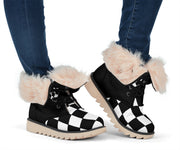 Women's black-and-white checkered boots worn with jeans, with cream-lined cuffs folded down.