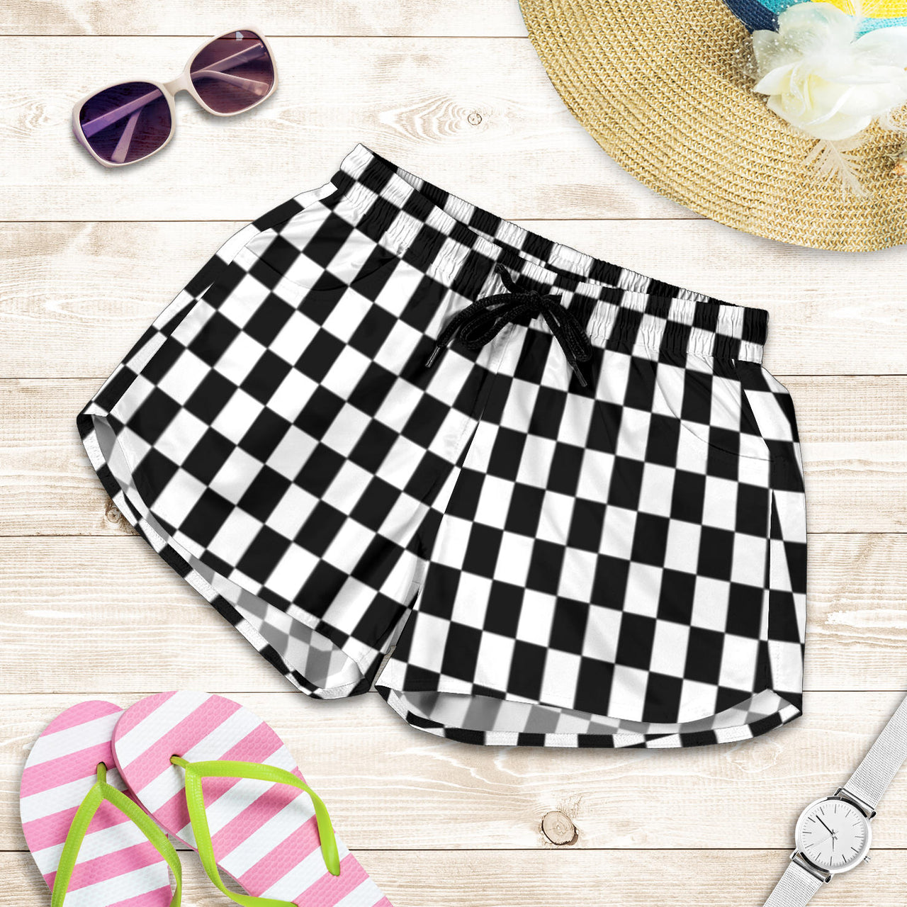 Women's high-performance athletic shorts featuring a bold black and white checkered flag pattern, designed with an elastic drawstring waist and functional side pockets.