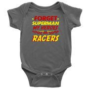 A young, excited child wearing a "Forget Superman My Superheroes Are Racers" t-shirt standing in the pit area, happily high-fiving a local race car driver dressed in a professional fire suit.