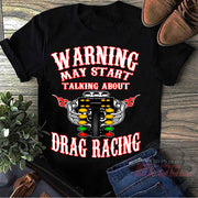 A premium black cotton t-shirt featuring the funny quote "Warning May Start Talking About Drag Racing" printed in bold white and high-visibility yellow typography, isolated flat on a solid white background.