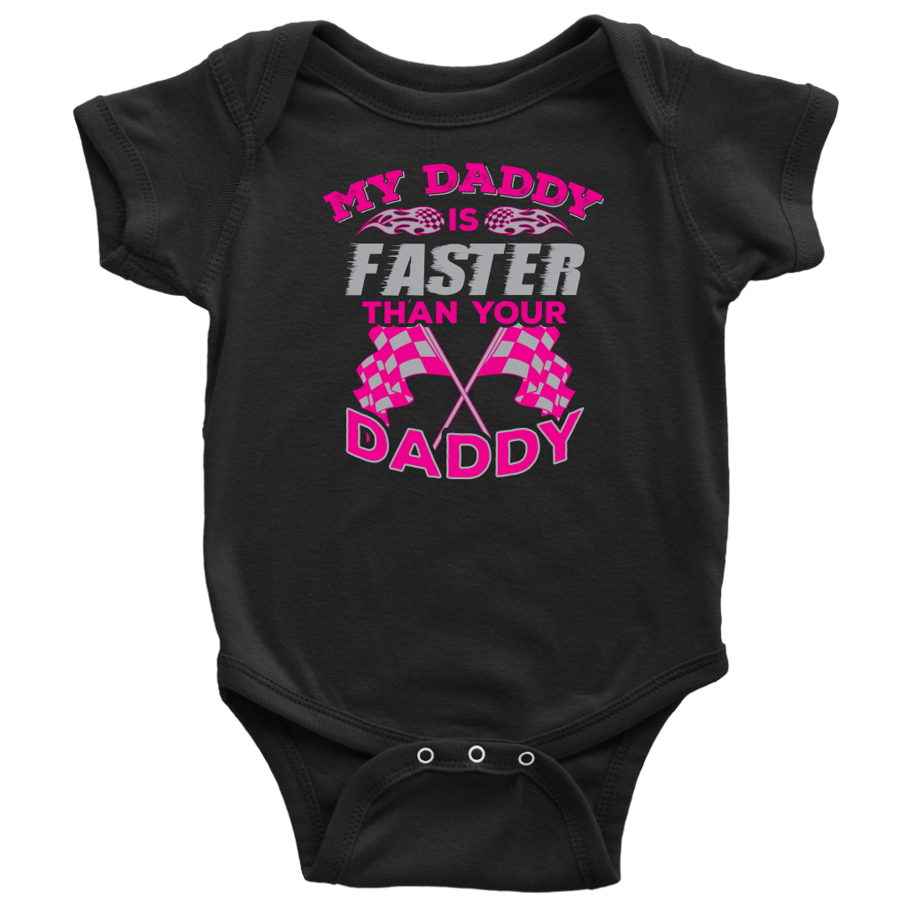 A proud, smiling racing dad in a fire suit holding his baby, who is wearing a cute "My Daddy Is Faster Than Your Daddy" bodysuit, standing confidently next to a colorful race car in the pit area.