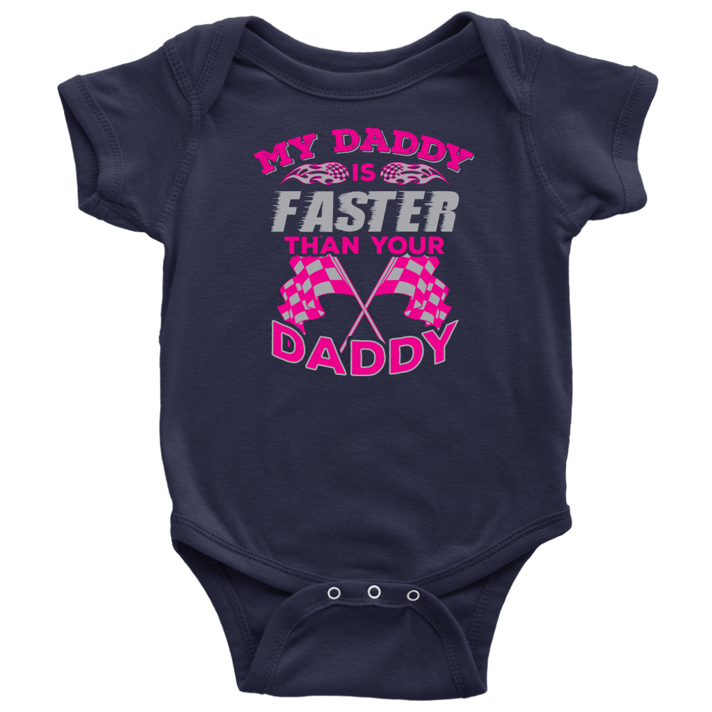 A proud, smiling racing dad in a fire suit holding his baby, who is wearing a cute "My Daddy Is Faster Than Your Daddy" bodysuit, standing confidently next to a colorful race car in the pit area.